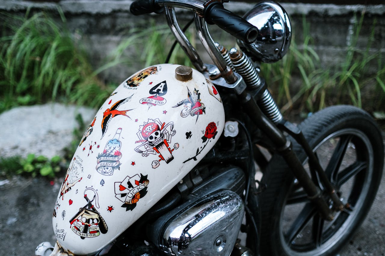services-01 Close-up of a vintage motorcycle with a decorated gas tank parked outdoors.